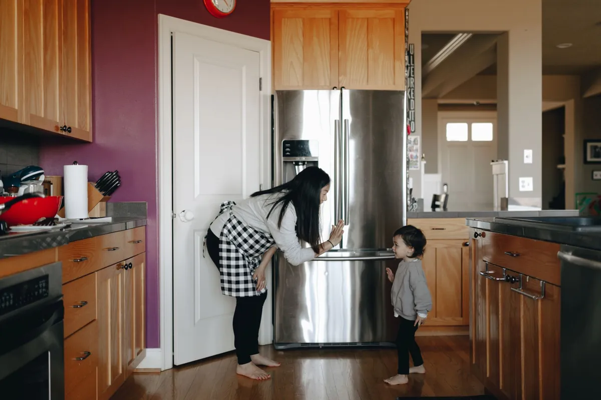 A mother interacting with her child in a cozy, modern kitchen setting.